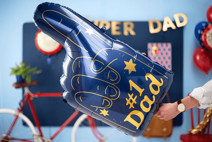 Blue foam-finger foil balloon reading “#1 Dad,” angled and held by hand.