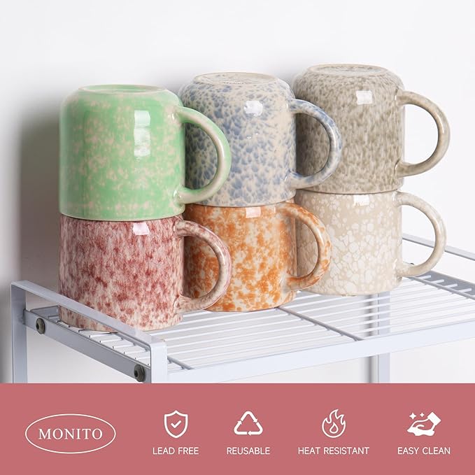 Stacked ceramic coffee mugs with handles, featuring green, speckled white, and tan colors