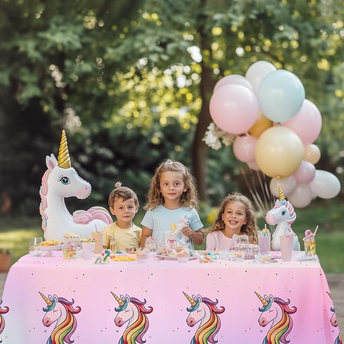 Unicorn tablecloth on party table with pink-and-white pattern featuring rainbow unicorns