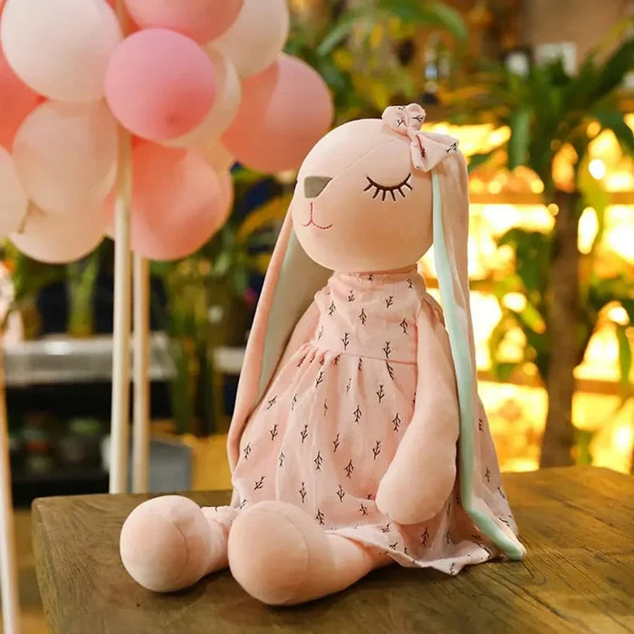 Pink sleeping rabbit plush toy sitting with mint-green ears and a cactus-pattern dress