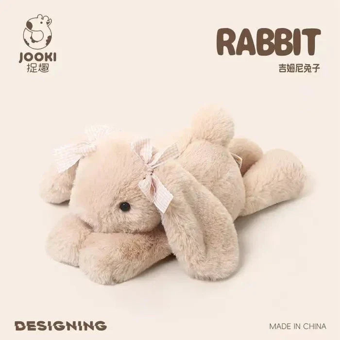Light beige plush rabbit pillow, ribbon bow on body, lying with legs forward.