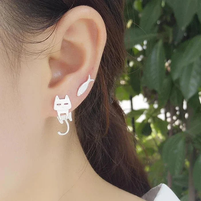 925 sterling silver cat-and-fish charm earrings on ear, cat face with fish drop