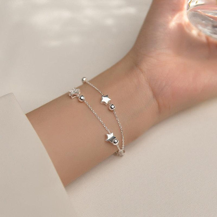 Sterling silver star bracelet on wrist with small star charms and bead accents