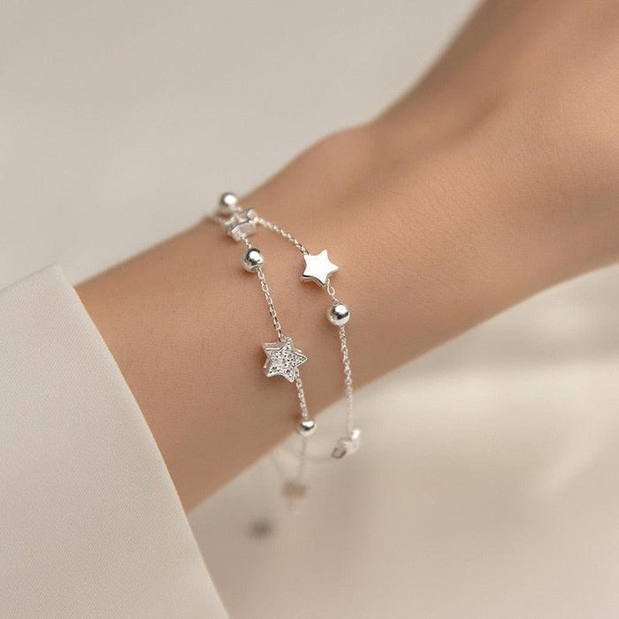 Sterling silver star bracelet with three star charms, beads, and a slim chain link
