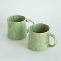 Mint green ceramic coffee mugs set of 2 with red and white abstract patterns