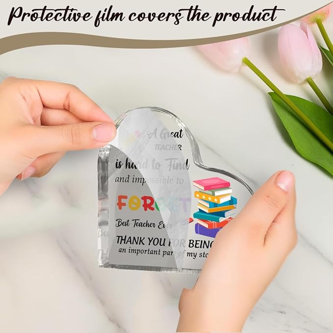 Hands holding clear acrylic heart plaque with protective film, “FORGET” teacher message inside