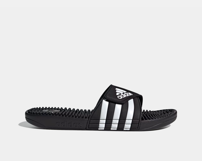 Adidas Adissage Slide sandals in black with white 3-stripe design, adjustable strap, and textured footbed, side view.