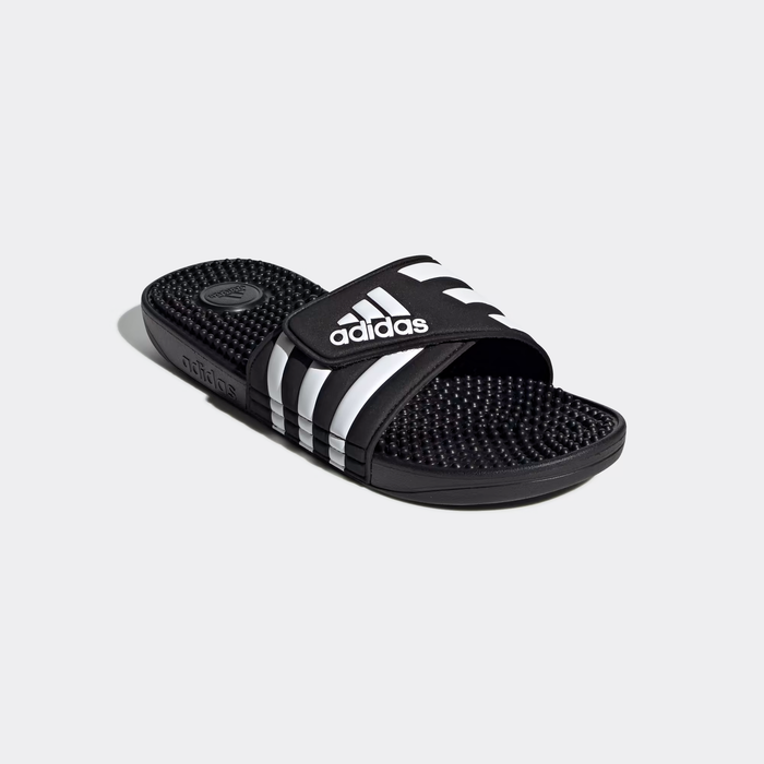 Adidas Adissage Slide sandals in black with white stripes, featuring a textured footbed and adjustable strap, angled side view.