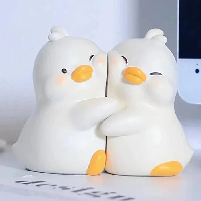 Close-up of white duck book ends facing each other with orange beaks