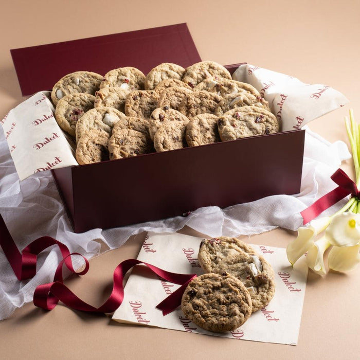 Oatmeal raisin cookies in a brown gift box with tissue paper and ribbon
