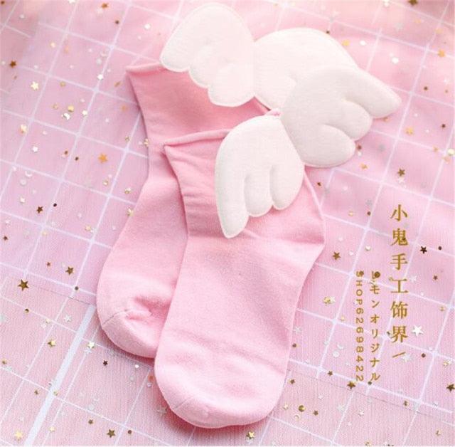 Pink crew socks with white angel-wing appliques at the ankle