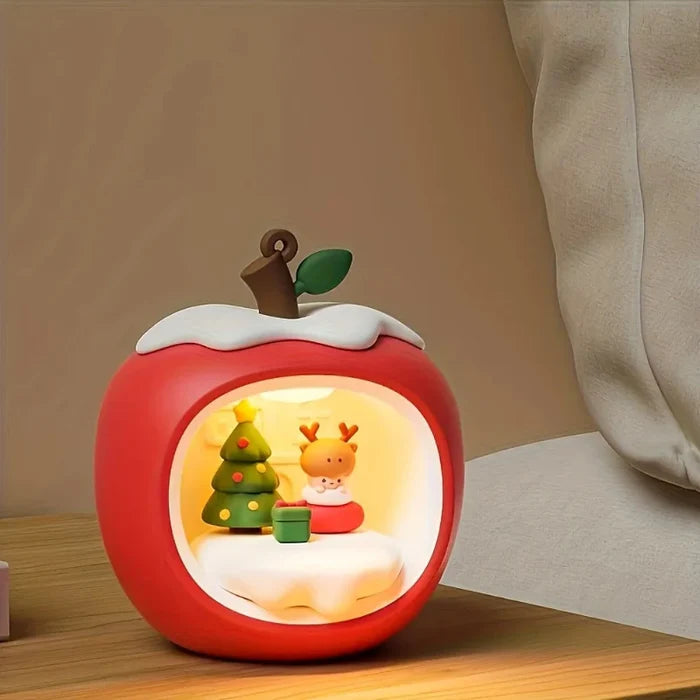 Apple night light with warm glow, red body and window showing cat and toys.
