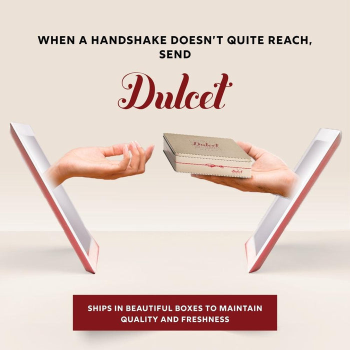 Two hands presenting a Dulcet scone gift tin in a decorative shipping box frame