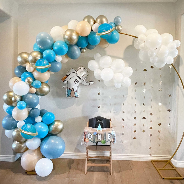 Blue, gold, and white astronaut balloon garland with hanging astronaut cutout