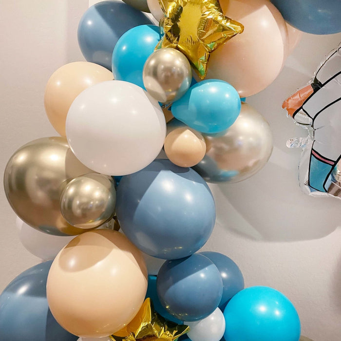 Close-up of gold, blue, and cream balloon cluster for an astronaut garland