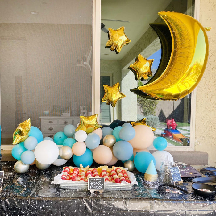 Balloon garland base with blue, gold, and white balloons and crescent gold star balloons