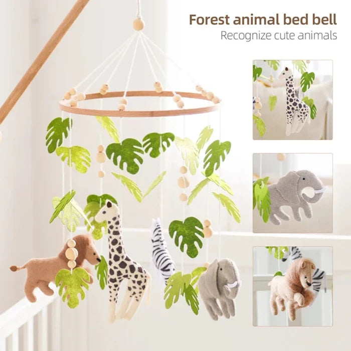 Crib mobile ring with hanging forest animal plushes, green leaves, and a bed bell
