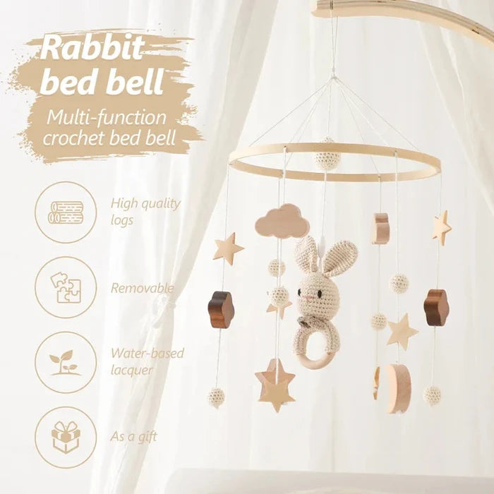 Baby bed bell mobile with crochet rabbit, star and cloud ornaments hanging from wooden ring