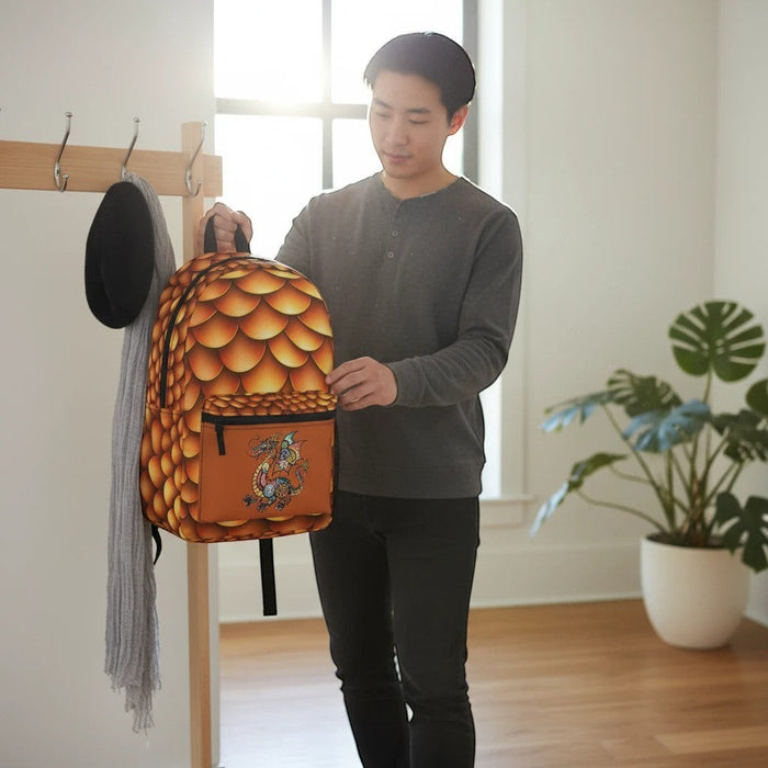 Dragon-scales backpack held up, showing front pocket and illustrated dragon