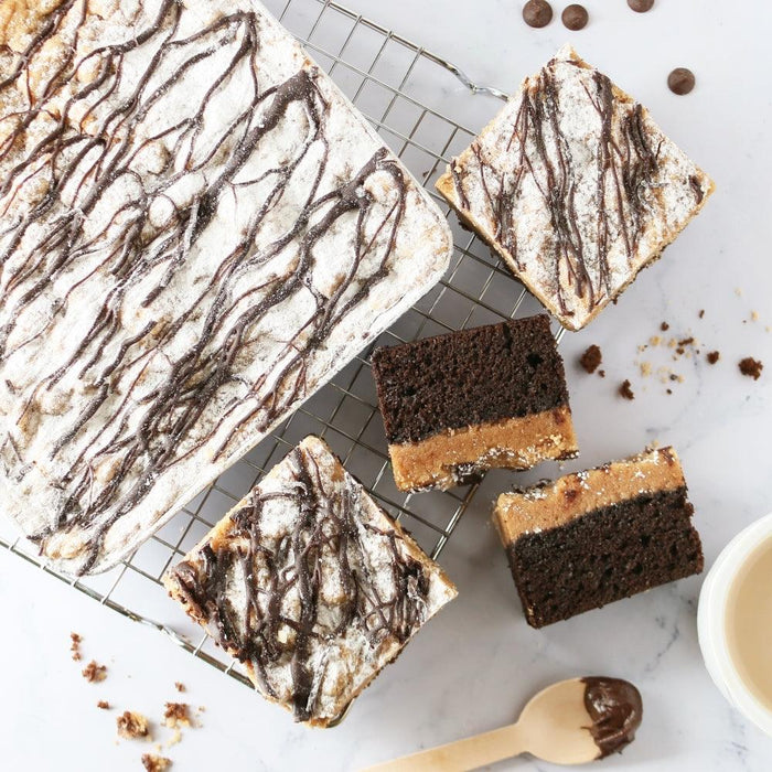 Fudgy chocolate brownies squares on wire rack, topped with powdered sugar.