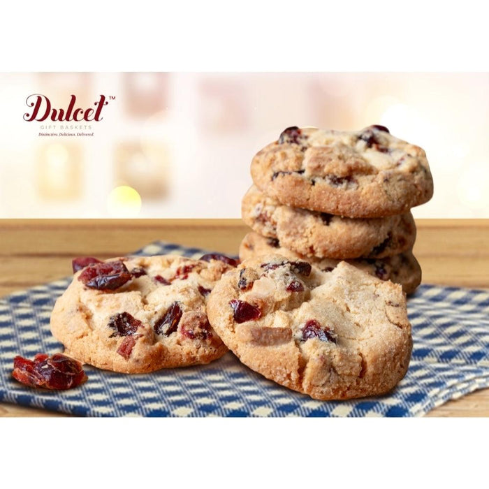 Stack of baked cookies with fruit bits on a blue-and-white cloth.