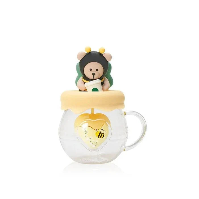Glass honey pot tea infuser mug with bear topper and yellow cap, curved side handle