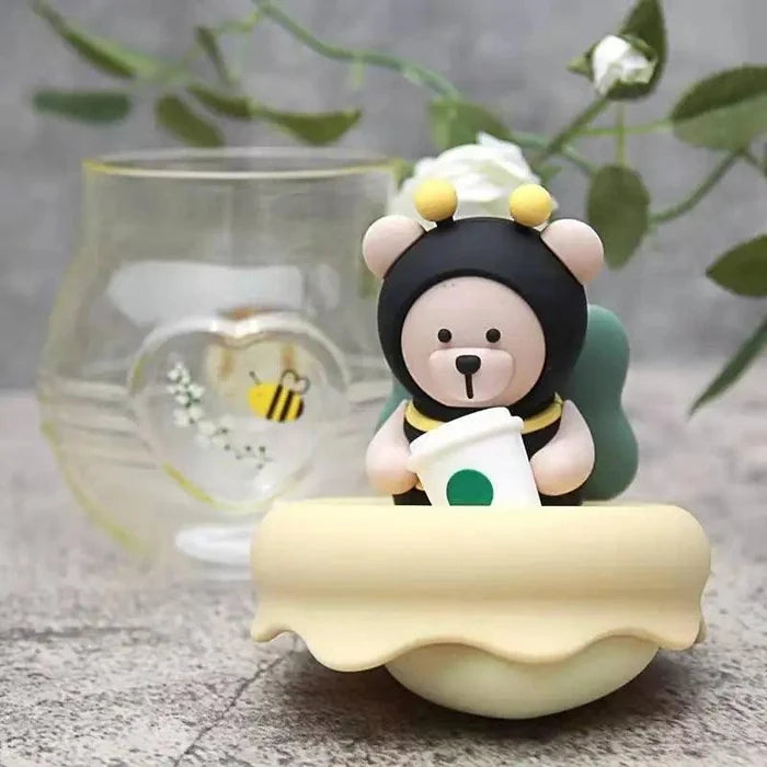 Glass tea infuser mug featuring a bear topper with green cap and honey-yellow lid