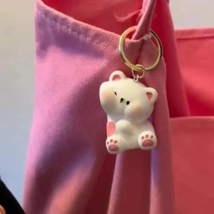 Single white bear magnetic keychain with gold key ring on a pink bag