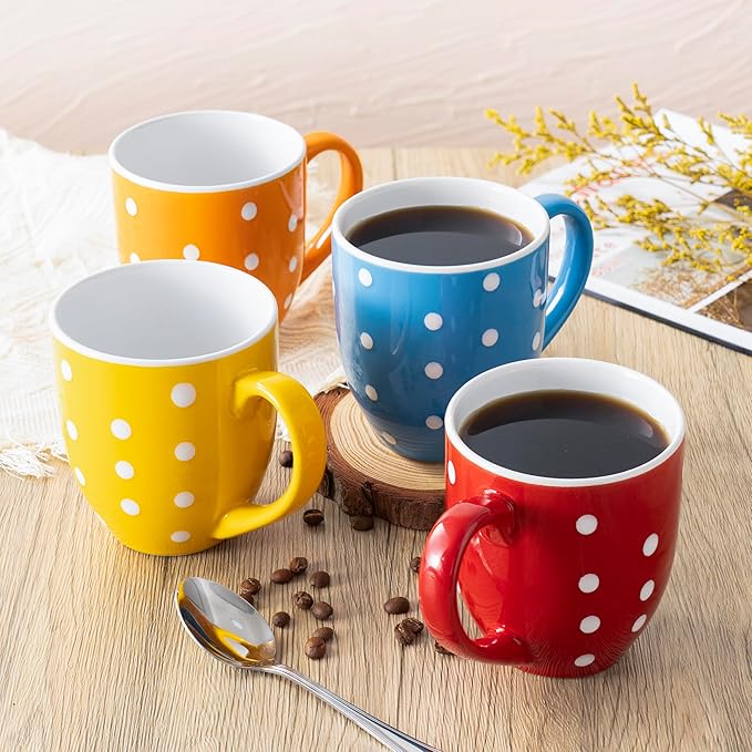 Ceramic coffee mugs with white polka dots in orange, yellow, blue, red, and navy on wood.