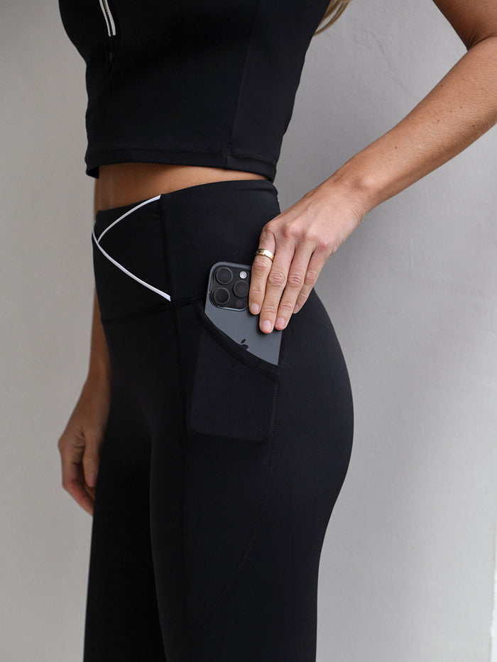 Billie Tipped bra top worn with the Billie  legging in black with white piping detAil from NAIA Active active wear collection