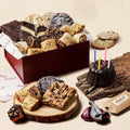 Red gift box filled with assorted cookies and brownies, with a birthday candle nearby