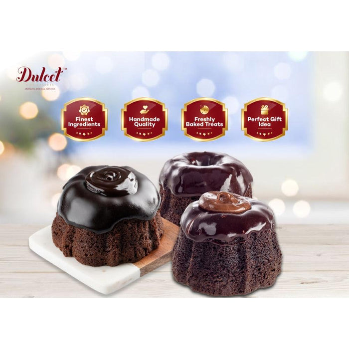 Three dark chocolate bundt cakes with glossy icing on a white serving tray