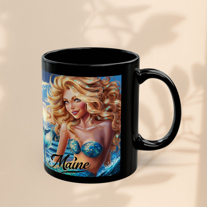 Black mug with mermaid portrait and 'Maine' script on blue ocean artwork
