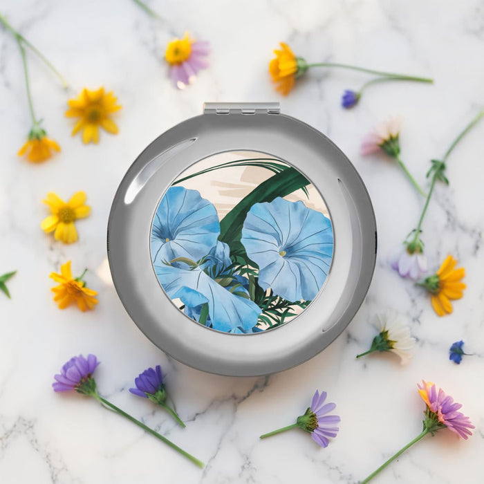Silver compact travel mirror, round floral design inset, top view, glossy finish