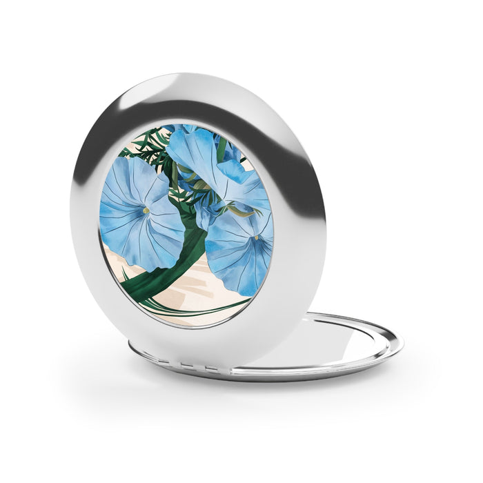 Silver compact travel mirror open on stand, round floral design inset, glossy finish