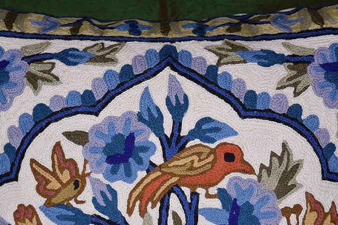 Blue floral tree motif pillow cover showing top border and embroidered bird in panel.