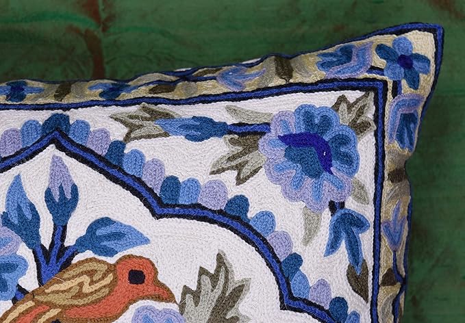 Blue floral pillow cover corner edge with decorative border and stitched bird motif.