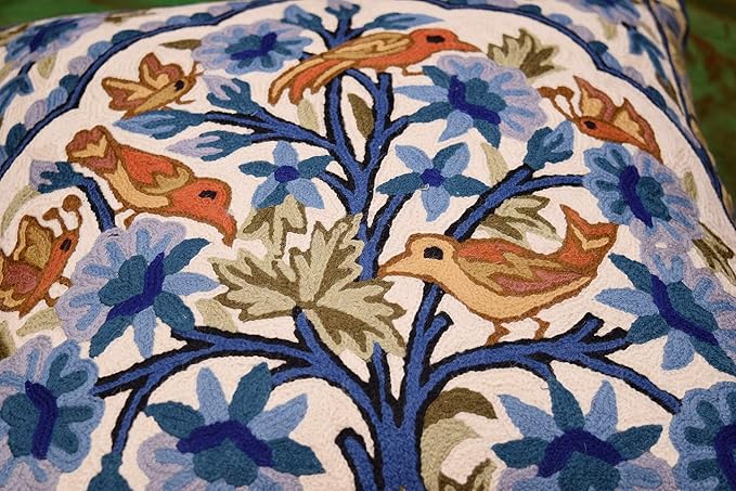 Blue floral pillow cover with tree of life embroidery and perched birds across center panel.
