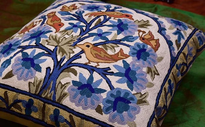 Blue floral embroidered pillow cover with birds and blossoms on front, framed by border.