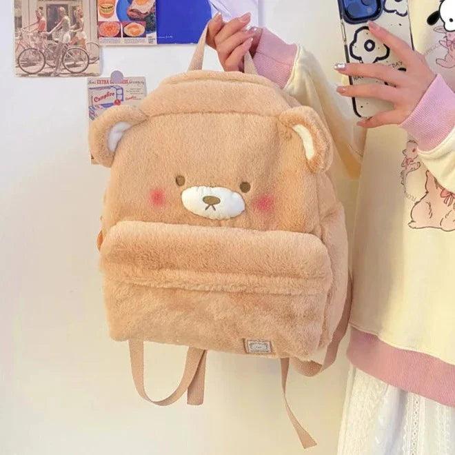 Light tan plush bear backpack with stitched face, front pocket, and small ear details