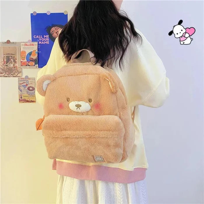 Light tan plush bear backpack worn from the back, with bear face patch and front flap