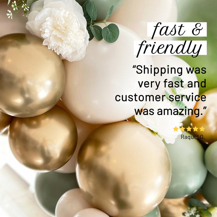 Balloon garland cluster with gold and cream balloons, greenery, and white flower accents