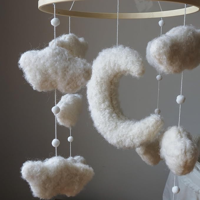 Crib moon mobile with large white plush moon and cloud charms on hanging strings