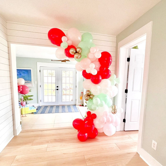 Pastel balloon arch garland with red, white, pink, and mint balloons with gold dots