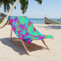 Beach towel with bright bubble print, draped on wooden lounge chair outdoors