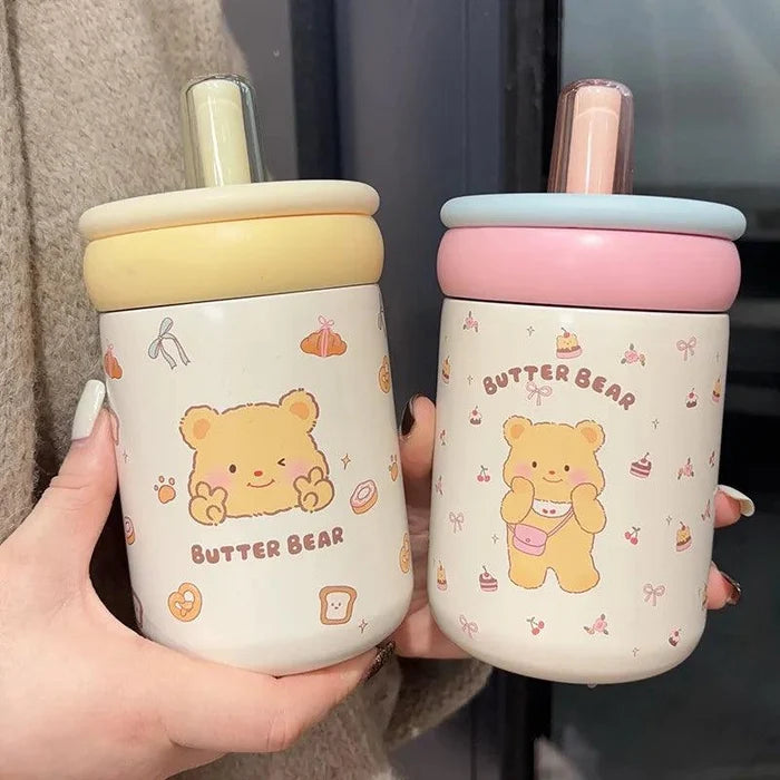 Two Butter Bear thermos cups, cream lid and pink lid, white bear graphics and straws
