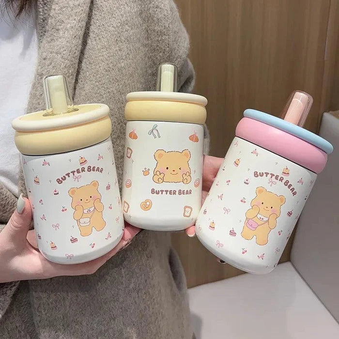 Three Butter Bear thermos cups with cream, yellow, and pink/blue lids, white bear prints