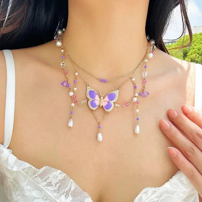 Gold multi-layer pearl necklace with blue butterfly pendant and pink crystal bead tassels