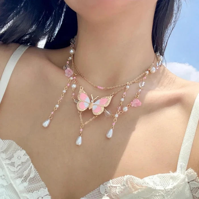 Gold multi-layer pearl necklace with pink butterfly pendant and dangling pearl teardrop beads