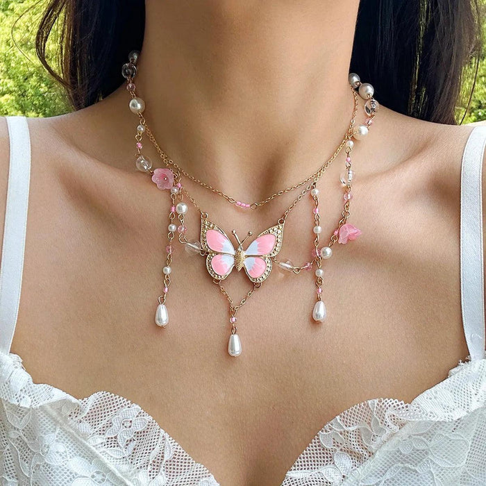 Gold multi-layer pearl necklace with pink butterfly center, pastel beads, and hanging pearl drops